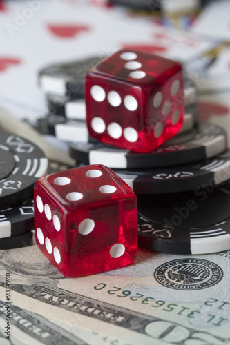 Two red dice, poker chips and US dollar bills