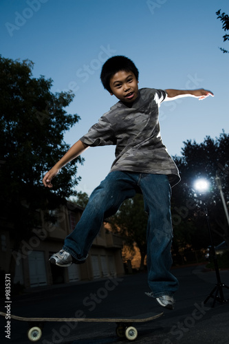 Young boy outside balancing on a skateboard