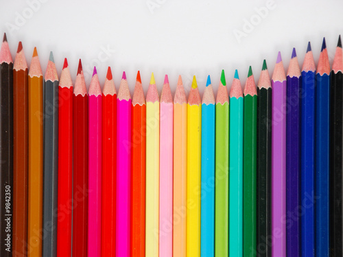 Assortment of coloured pencils with shadow on white background