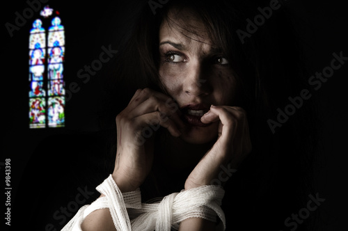 woman in fear with patch around her arms an a church