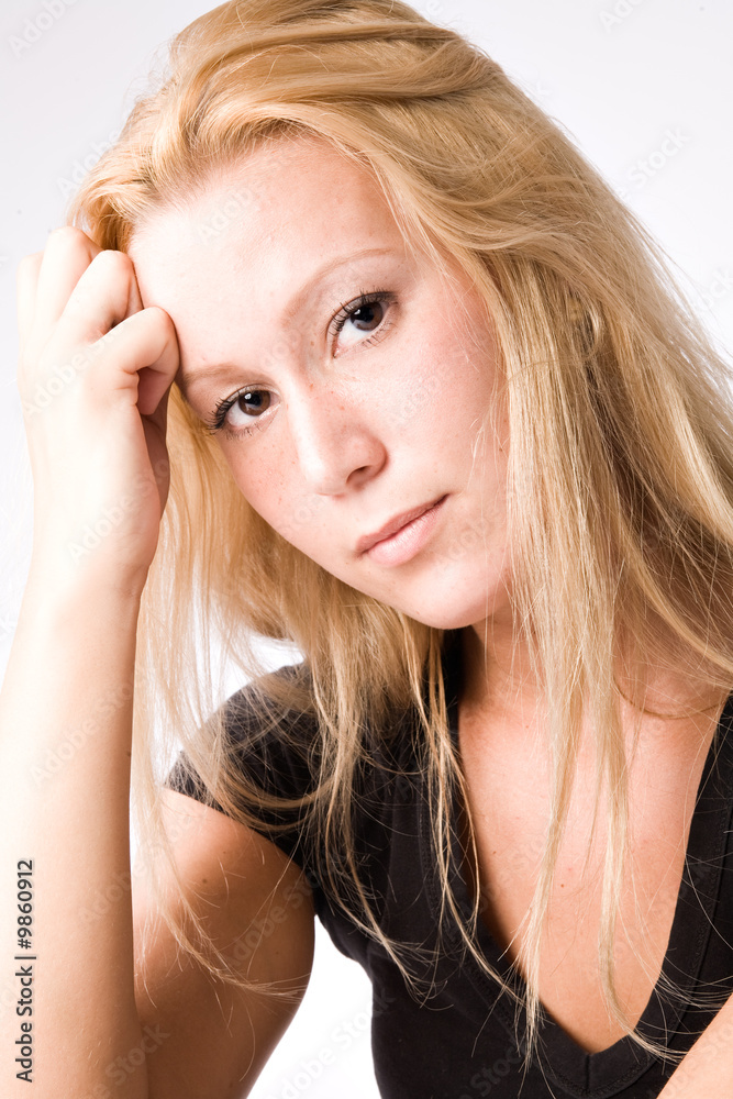 Studio portrait of a young blond girl looking pensive