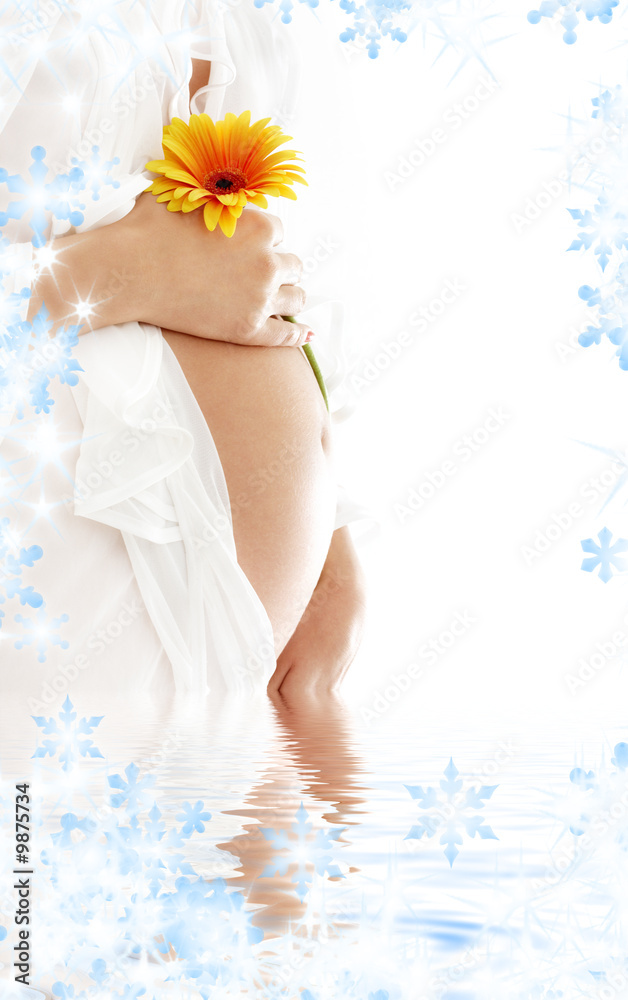 pregnant woman holding her belly and yellow flower in water pregnant woman holding her belly and yellow flower in water