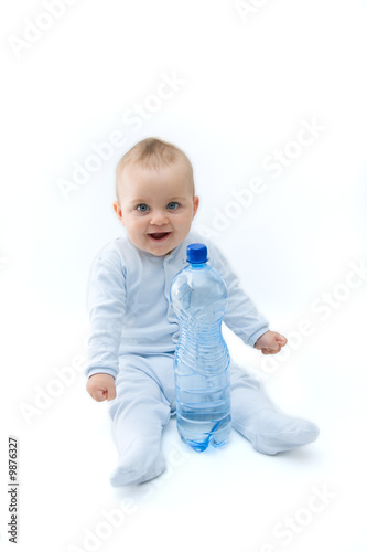 baby boy and bottle of mineral water, on white