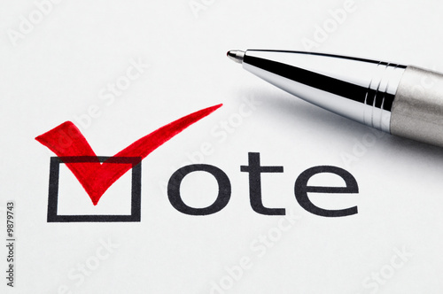 Red checkmark on vote checkbox, pen lying on ballot paper.