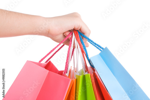 Woman hand holding several shopping bags isolated on white.