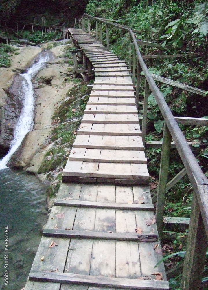 a wooden bridge over waterfall