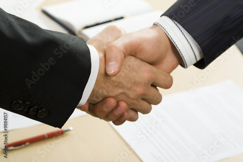 Картината върху платно Photo of business handshake over workplace