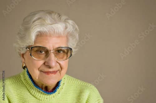 Senior lady portrait, smiling, with glasses, with copy space.