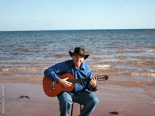Man plays guitar at the beach © rusty elliott