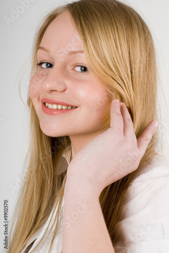 close-up of a young pretty long-haired smiling blond girl