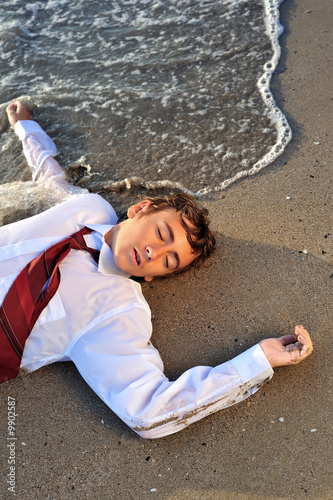 Young boy lying on back on beaach © Orlando Florin Rosu