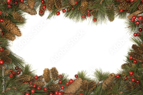 Christmas border of pine branches against white background