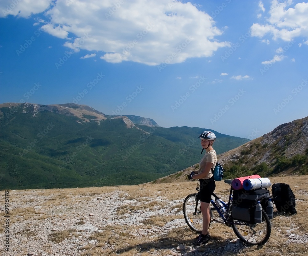 Woman travel with bike in Crimea mountains.