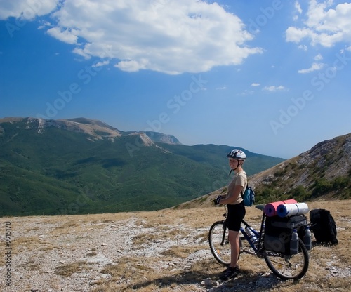 Woman travel with bike in Crimea mountains.