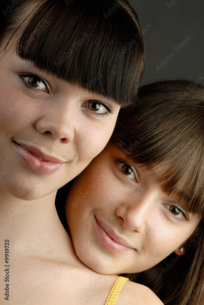 Portrait of two cheerful young girls in studio, close-up Portrait of two cheerful young girls in studio, close-up