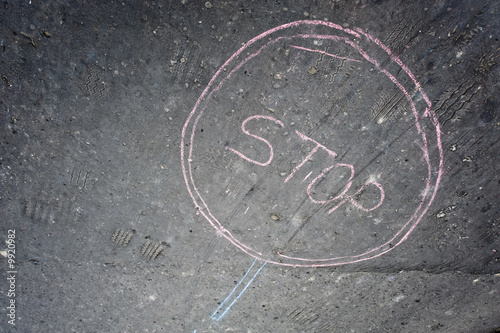 Painting of stop sign made written by chalk on asphalt