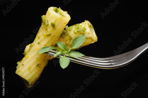 Italian pasta with pesto on fork isolated on black