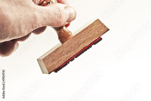Hand hält Stempel und stempelt damit ab