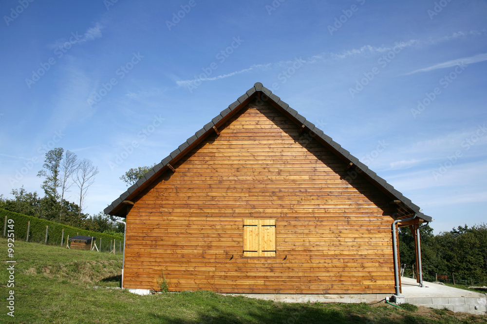 Wooden chalet in green garden and blue sky, Correze, France