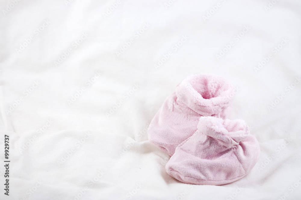 A pair of cute pink baby shoes on a white background