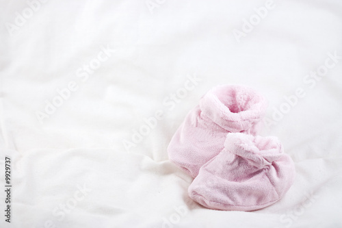 A pair of cute pink baby shoes on a white background