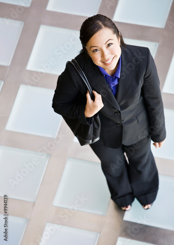 Businesswoman in full suit standing with purse