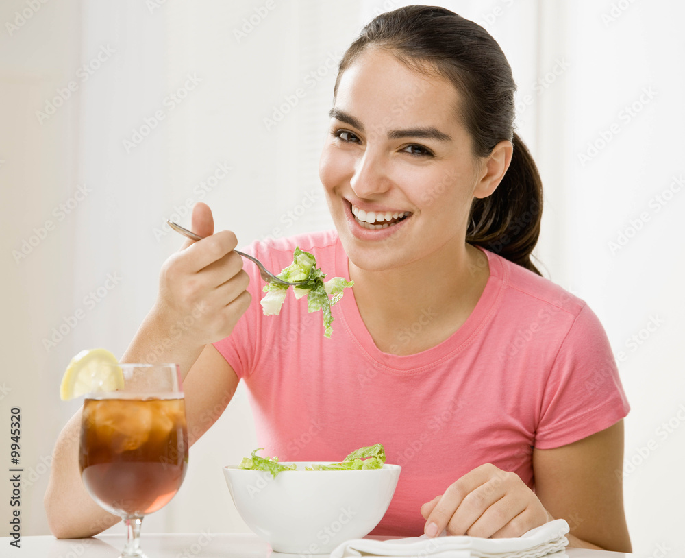 Happy woman eating wholesome, fresh bowl of salad Happy woman eating wholesome, fresh bowl of salad