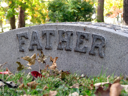 autumn cemetery grave headstone marked with father
