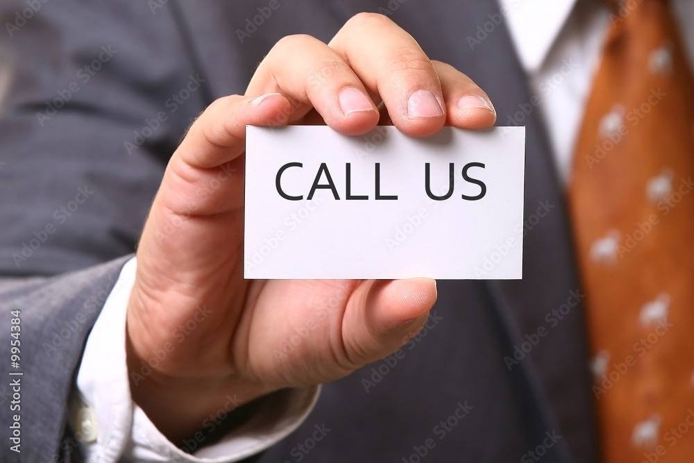 Business man holding card with text CALL US Business man holding card with text CALL US