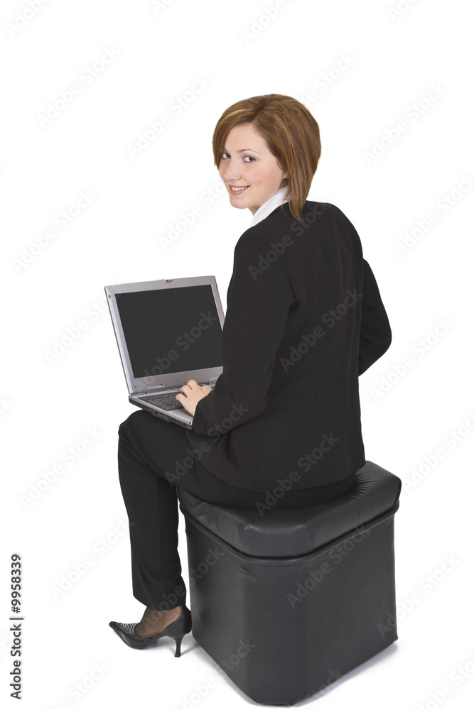 Businesswoman sitting on a pouffe with a laptop Businesswoman sitting on a pouffe with a laptop