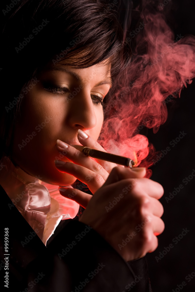 Fototapeta premium nice young girl is smoking in studio
