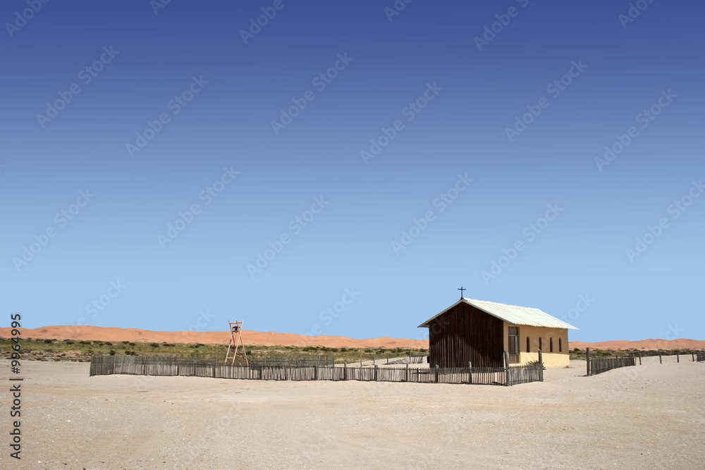 remote church in namib desert with  red dunes in background