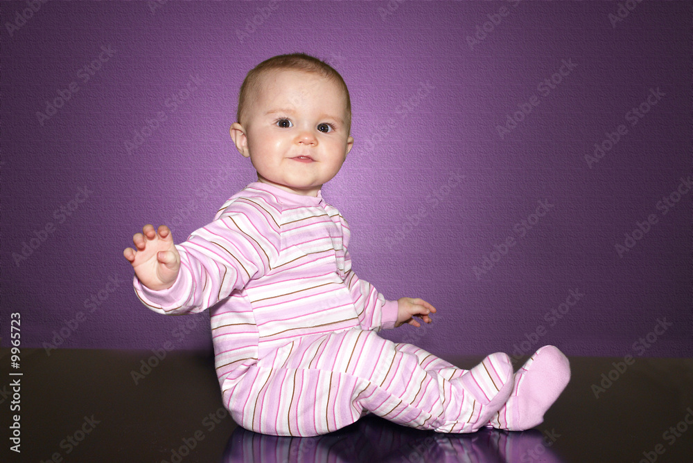 baby of ten months old seating down over a dark table