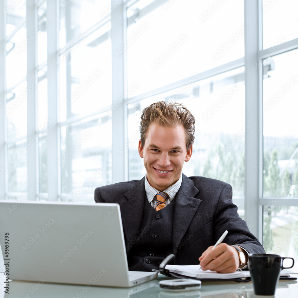 Happy smiling businessman working on laptop computer Happy smiling businessman working on laptop computer