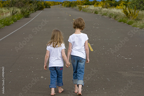 children walking down empty road