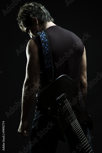 young man with guitar in the darkness
