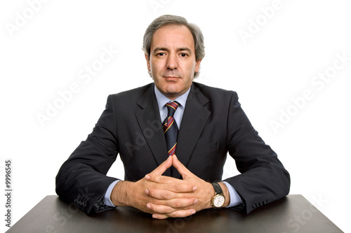 mature business man on a desk, isolated on white