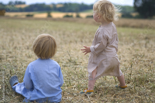 two boys playing in a summer field during harvesting photo