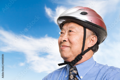 A senior asian businessman wearing a bike helmet outdoor © arekmalang
