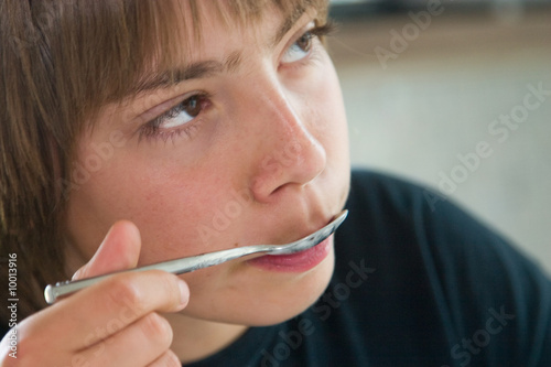 jeune adolescent mangeant son yaourt