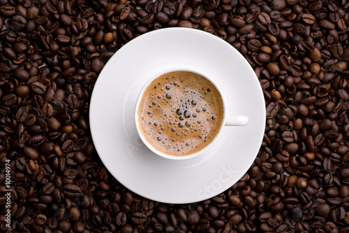 Kaffe in Tasse Untergrund aus Kaffeebohnen Vogelperspektive