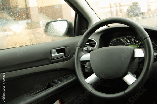 the empty driver's place in car, steering wheel closeup © Lykovata