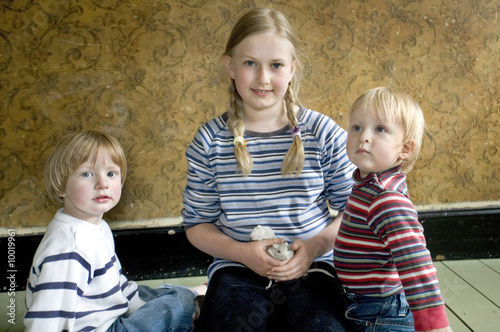 three children sitting together with thier pet gerbills photo