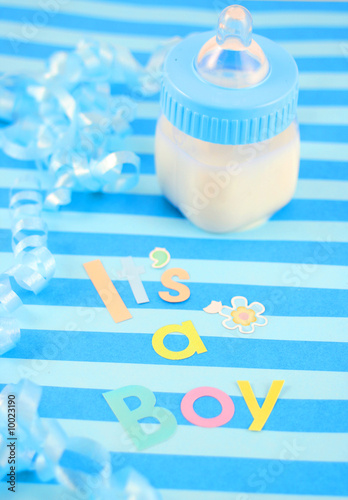 a blue baby bottle with milk and celebratory it's a boy text photo