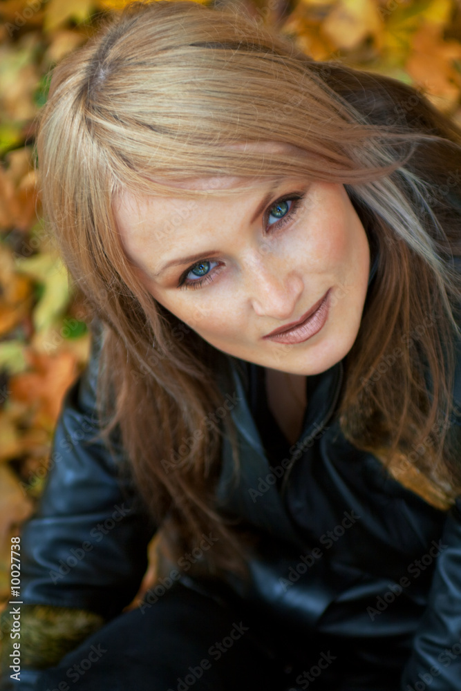 Naklejka premium Girl in autumn park looking attentively at you