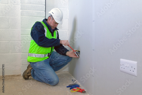 Фотография An electrician installing an electrical socket