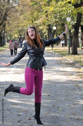 Happy young woman jumping in nature photo