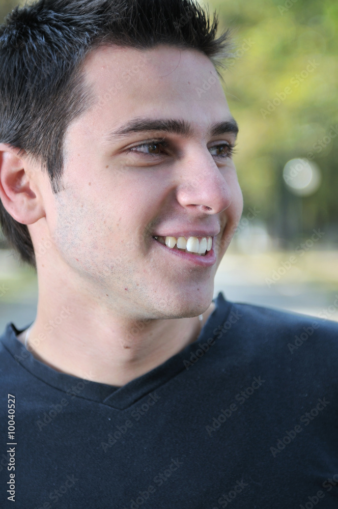 Obraz premium Handsome young man smiling outdoors in nature