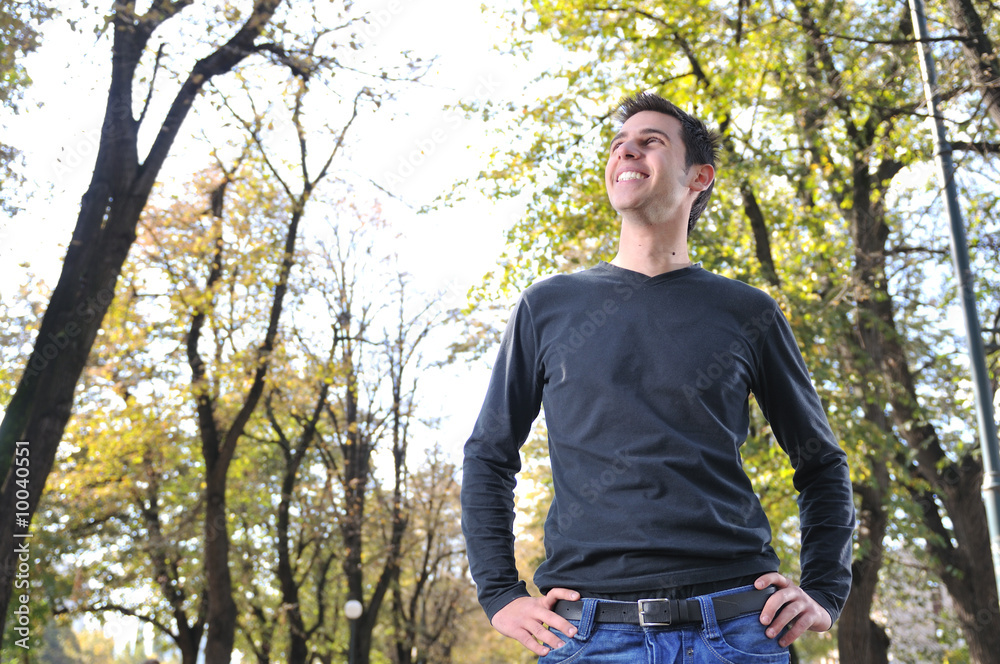 Handsome young man smiling outdoors in nature Handsome young man smiling outdoors in nature