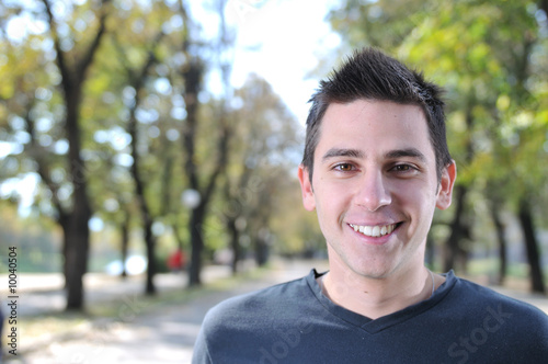 Handsome young man smiling outdoors in nature